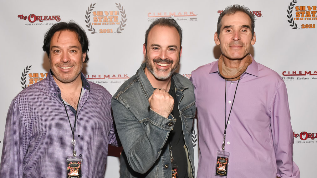 Three men posing in front of a white backdrop
